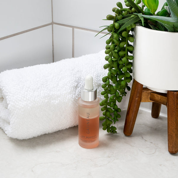 Gatineau Age Benefit Youth Revitalising Oil Serum next to a plant and bathroom towel