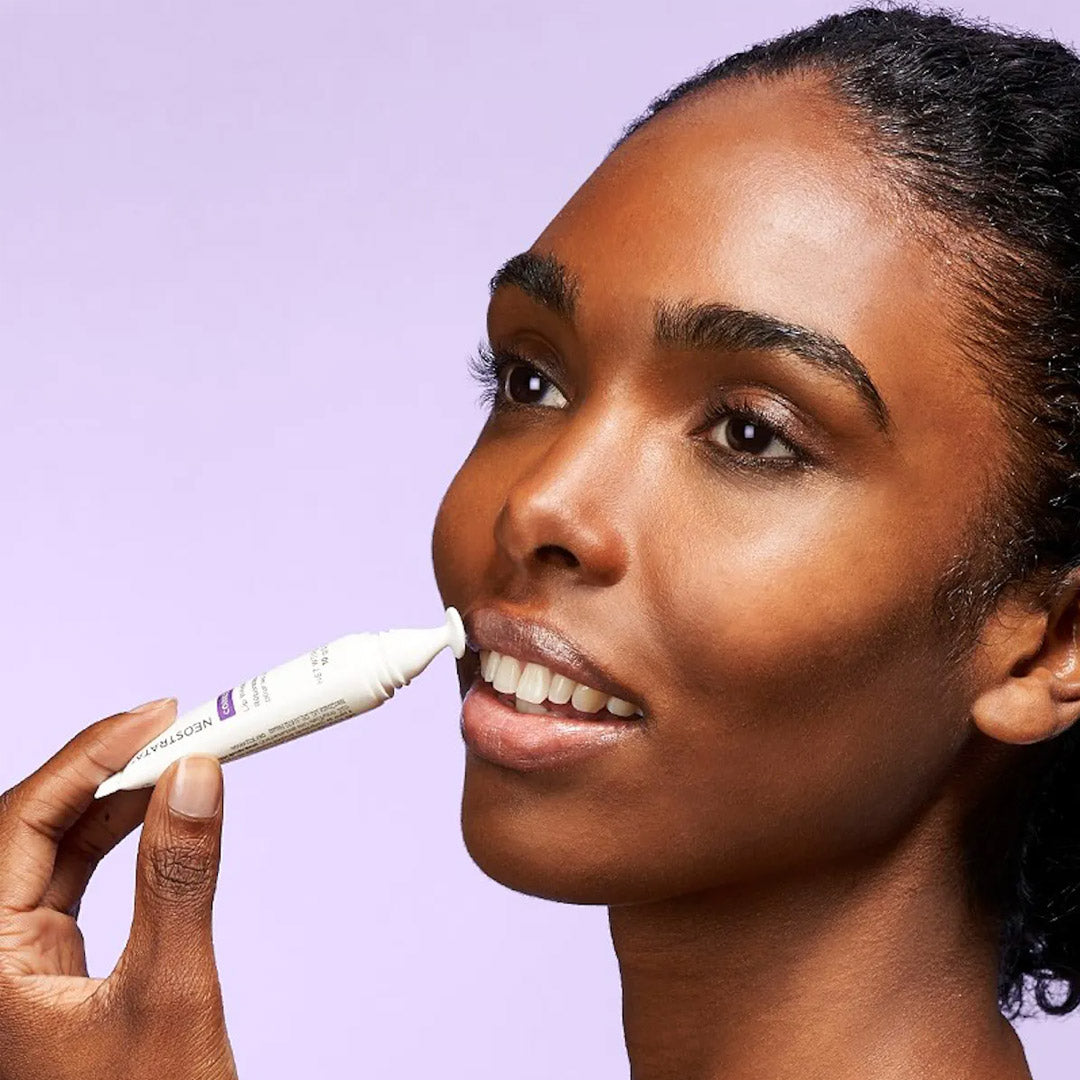 model applying the repair to her lips