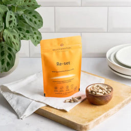 Rejuvenated Re-Set on a wooden chopping board and small cup of capsules