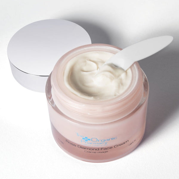 Open The Organic Pharmacy Rose Diamond Face Cream tub with spatula