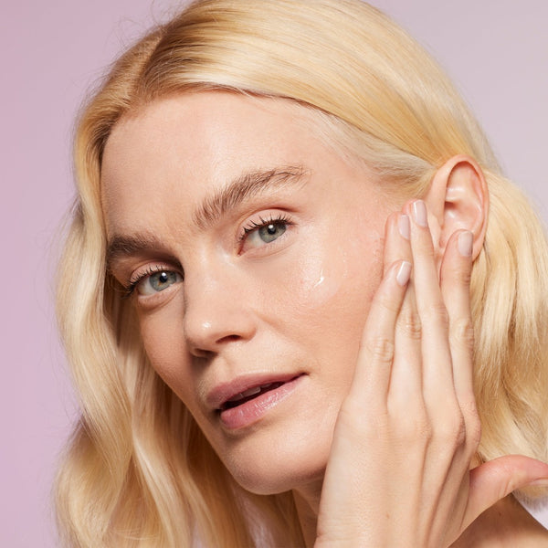 a model applying the serum to her face