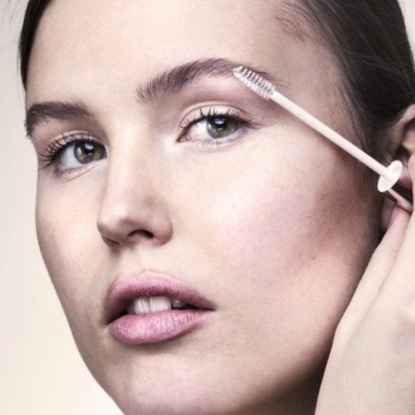 a woman using Swiss Clinic Eyebrow Growth Serum 