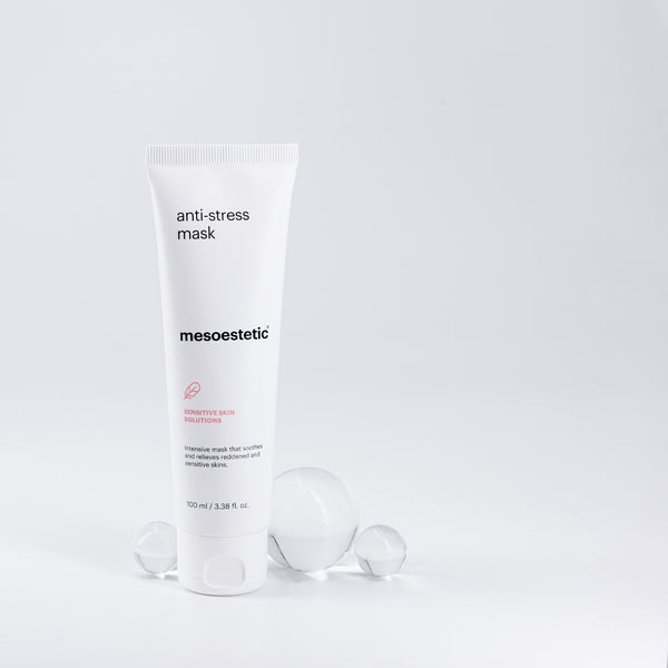 A tube of mesoestetic Anti-Stress Mask with three glass orbs behind it