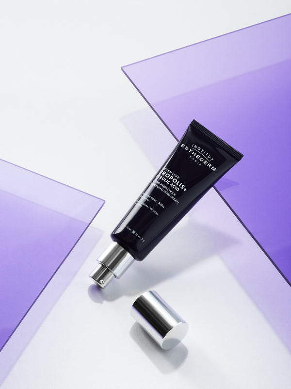 A Institut Esthederm Intensive Propolis+ Skin Perfecting Cream Tube placed on a purple glass shard