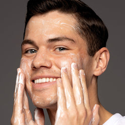 a man applying facewash to his face