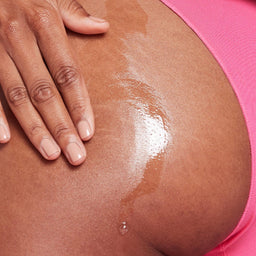 a close up of a women applying body oil