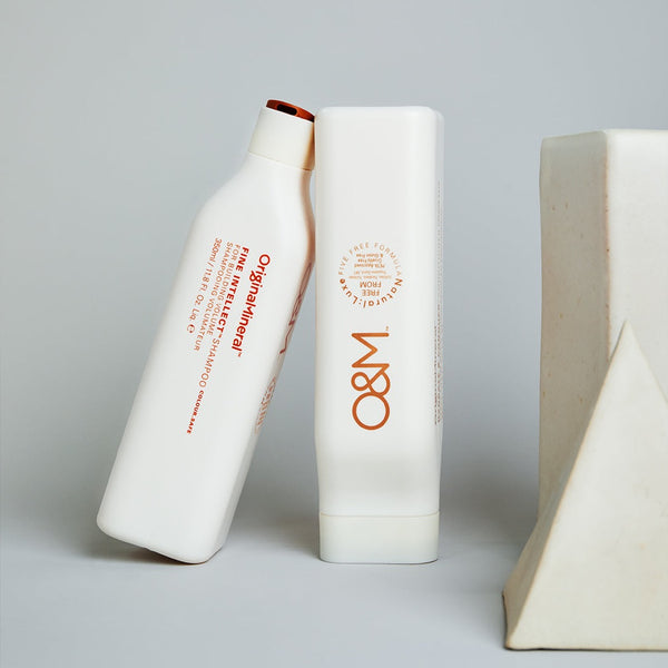 O&M Fine Intellect Shampoo bottles next to two ornaments 