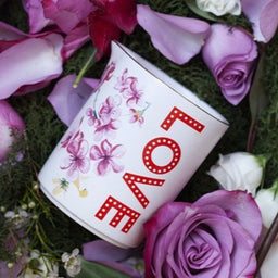 OSKIA & Temperley Skin Smoothing LOVE Candle surrounded by petals