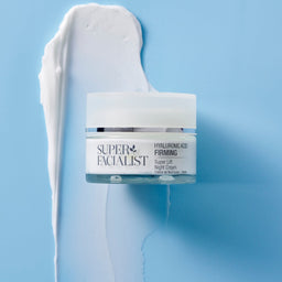 Hyaluronic acid night cream jar on top of a white creamy texture swatch on blue table