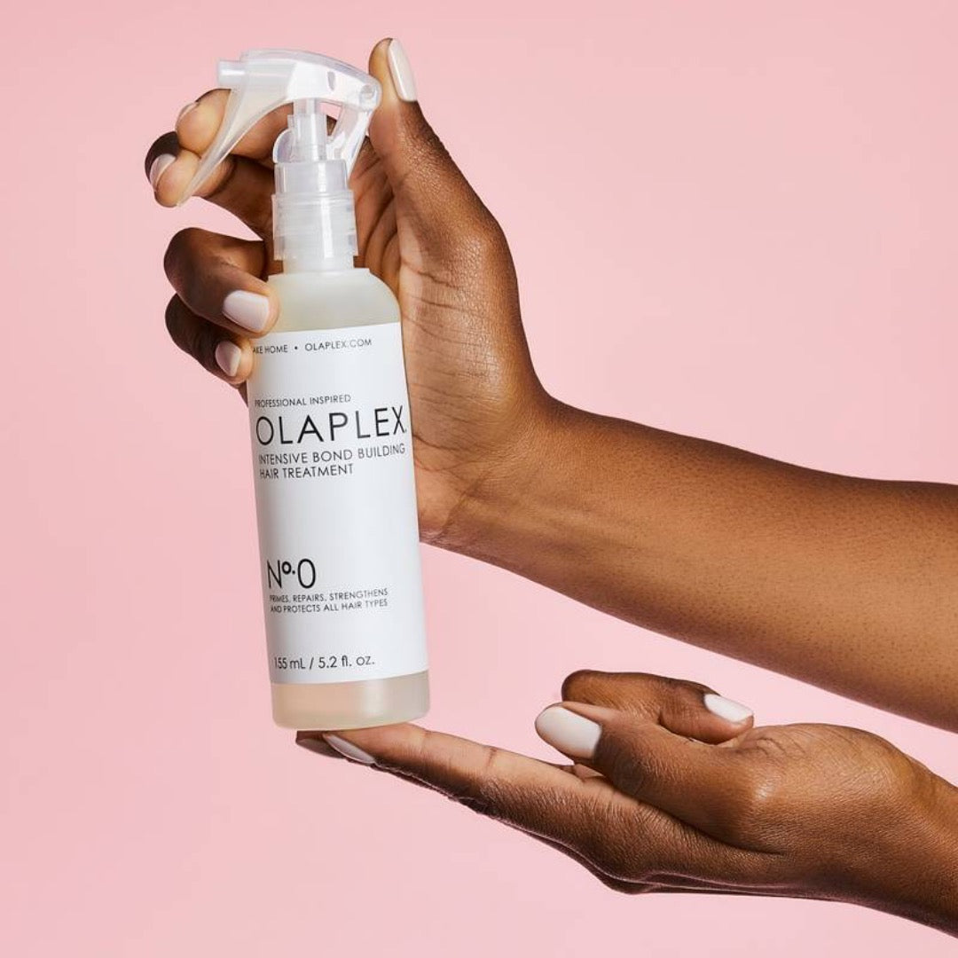a model holding a bottle of Olaplex No.0 Intensive Bond Building Hair Treatment